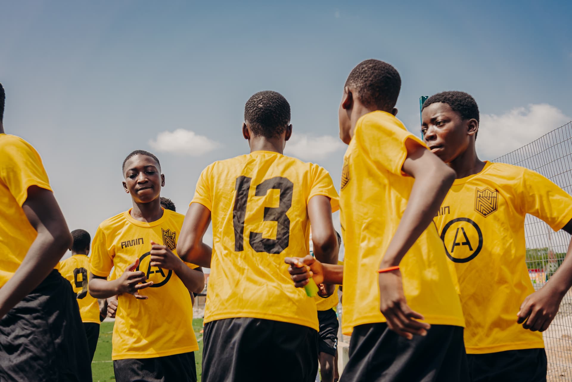Players in a huddle exchanging handshakes before kick-off