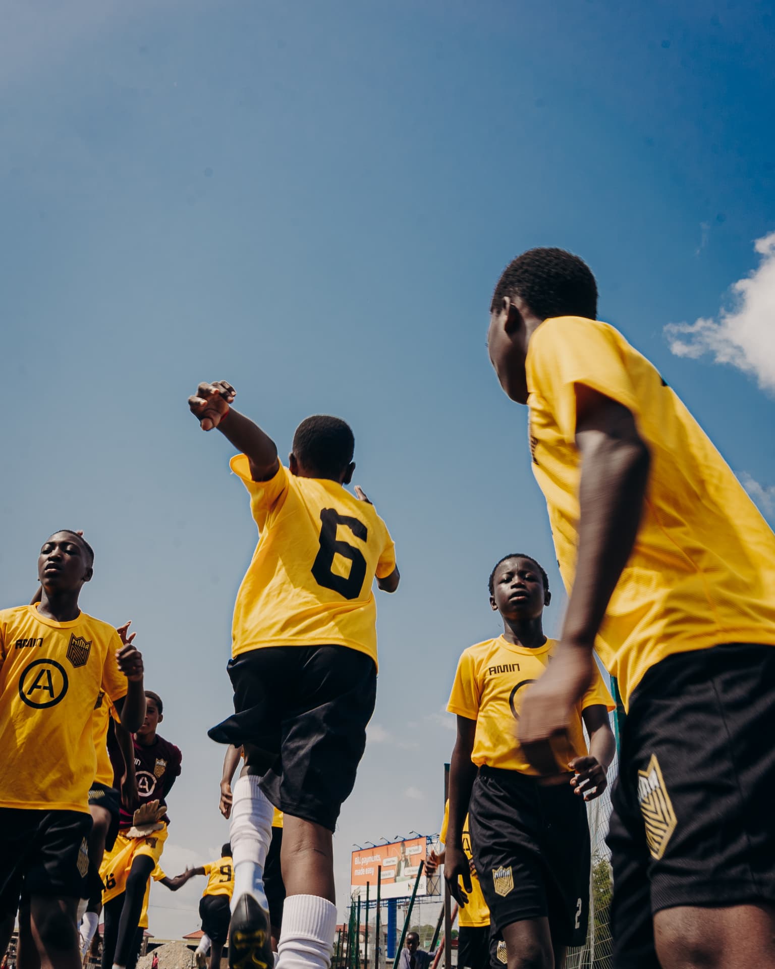 Grassroots players warming up under a blue sky