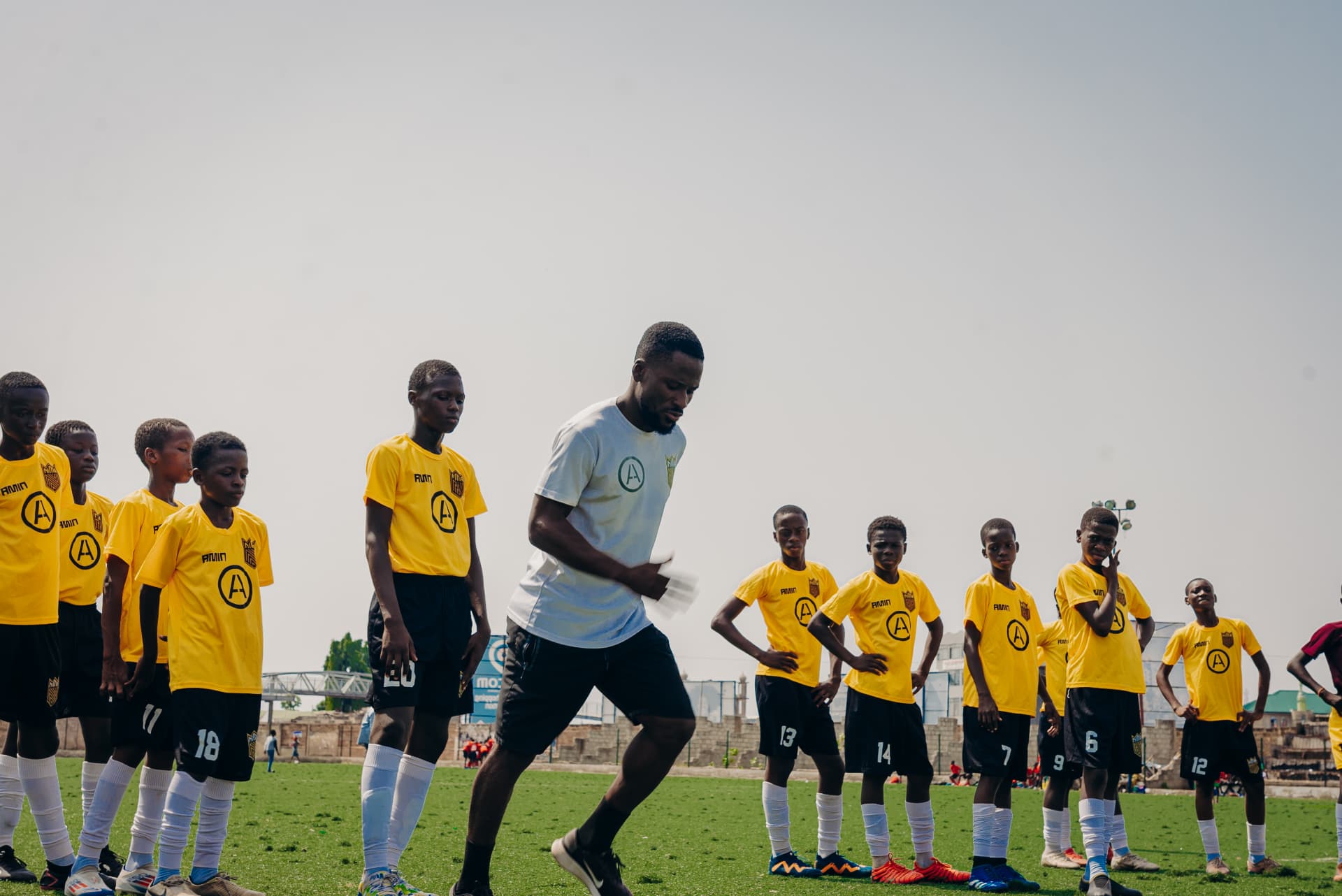 Coach leading a line-up of grassroots players before training