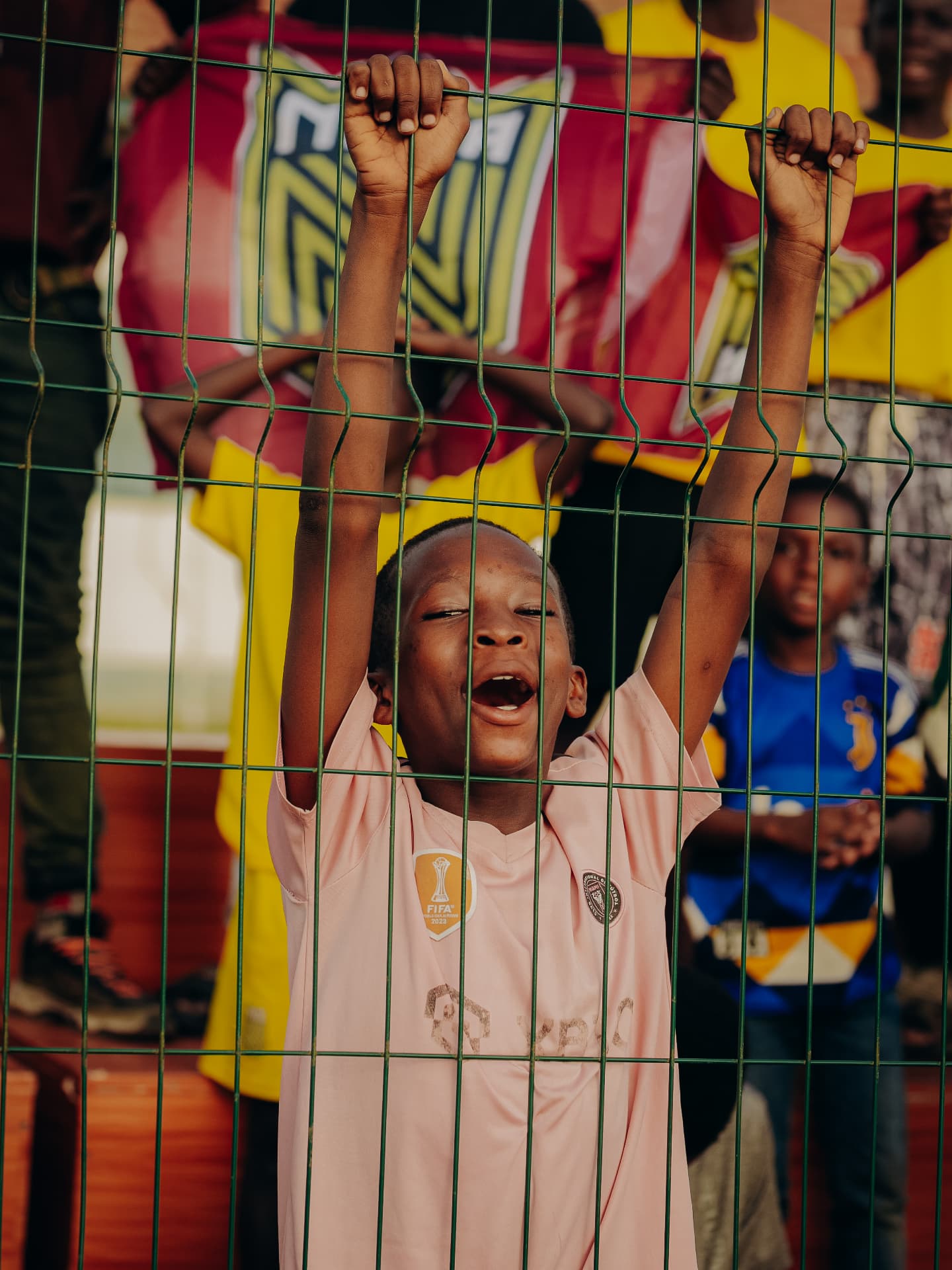 Young Nima Kings FC supporter cheering at the fence