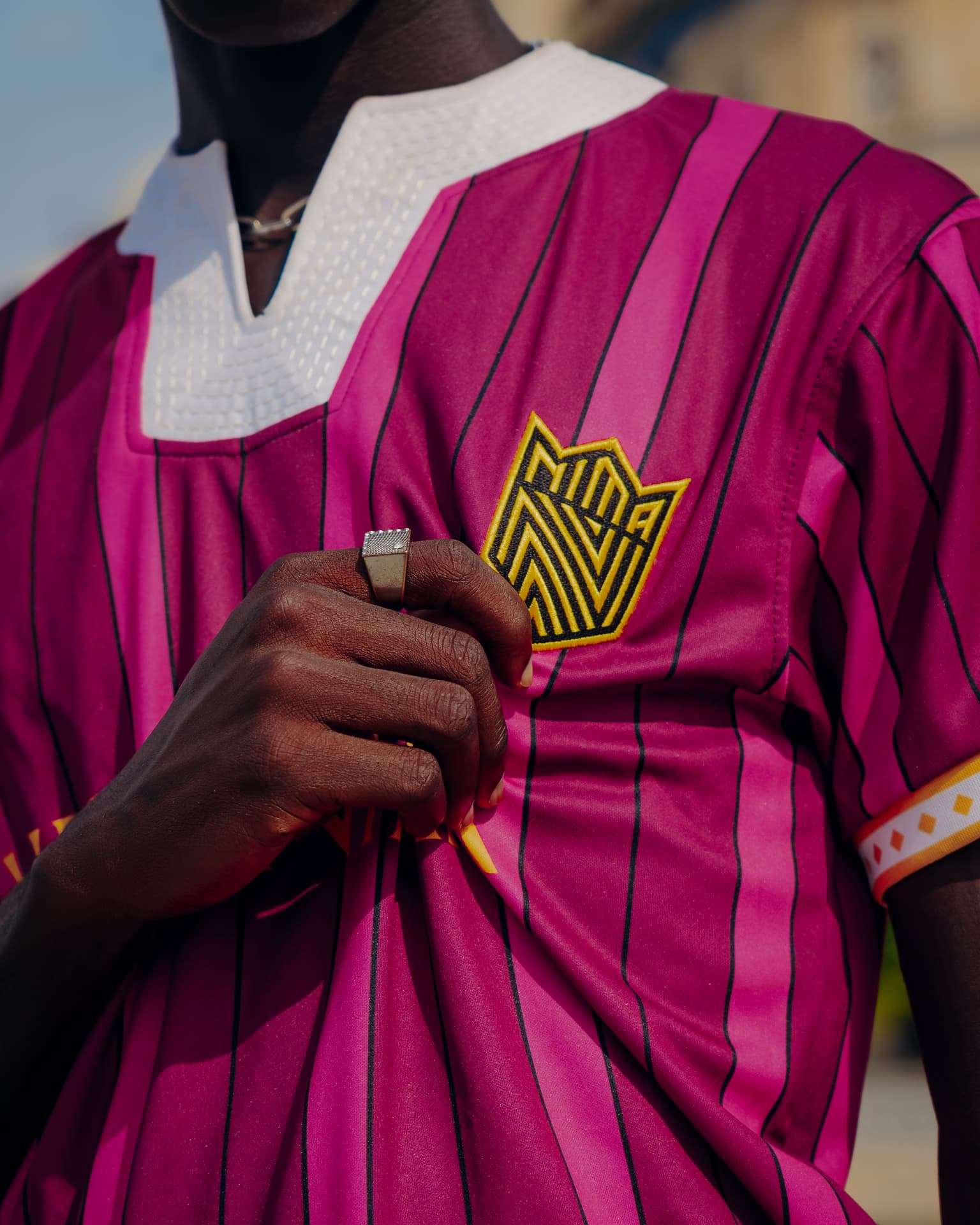 Close-up of the golden Nima Kings FC crown embroidered on the Fugu Jersey